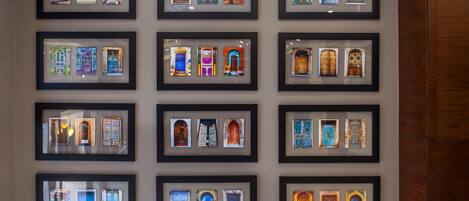 A wall with multiple framed pictures of doors and windows.