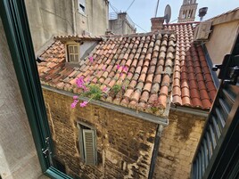 Ein Gebäude mit Ziegeldach, einem kleinen Fenster mit Rollläden und einer Satellitenschüssel.