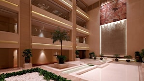 A modern indoor atrium with multiple floors, large windows, and a central water feature. - Guangzhou Marriott Hotel Tianhe (Guangzhou)