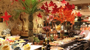 A buffet with various food items and decorations, including a pineapple and red maple leaves. - Guangzhou Marriott Hotel Tianhe (Guangzhou)