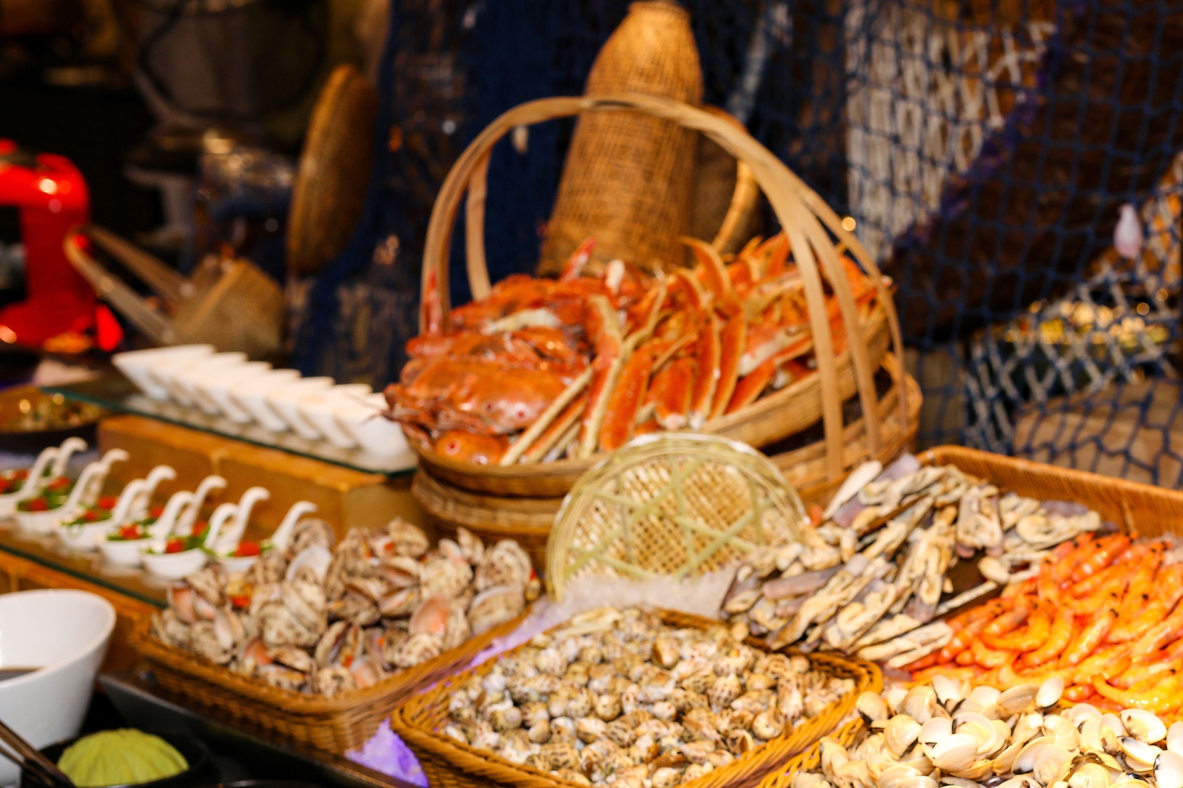 A seafood display with various types of shellfish and seafood arranged in baskets and trays.
