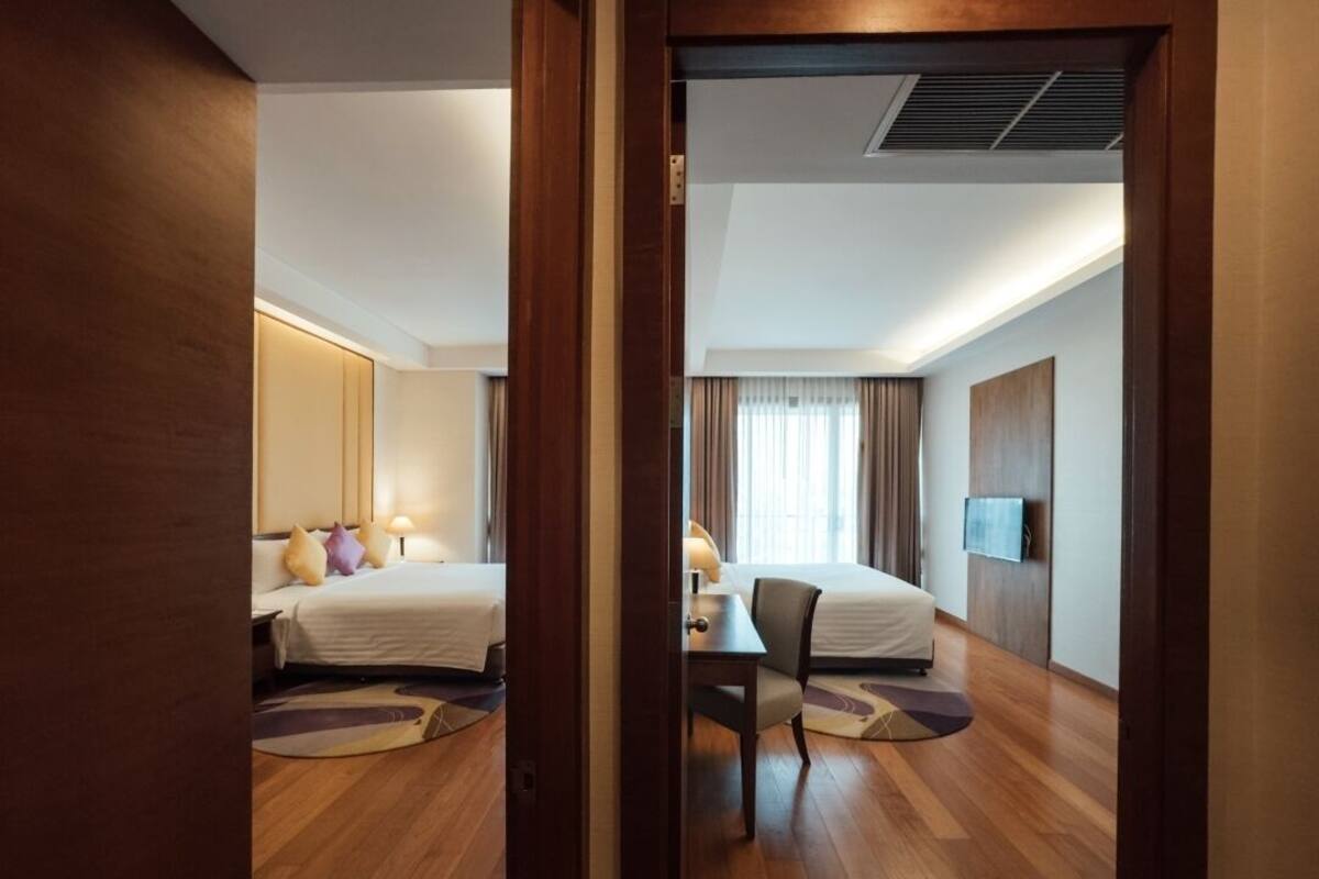 Una habitación de hotel con dos camas, un escritorio y un televisor.