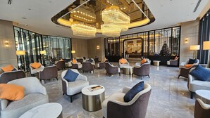 A spacious lobby with modern furniture, large chandeliers, and a Christmas tree. - Column Bangkok Hotel (Bangkok)