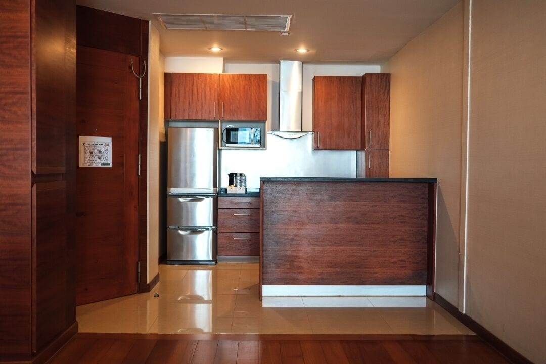 A compact kitchen with wooden cabinets, stainless steel appliances, and a central island.