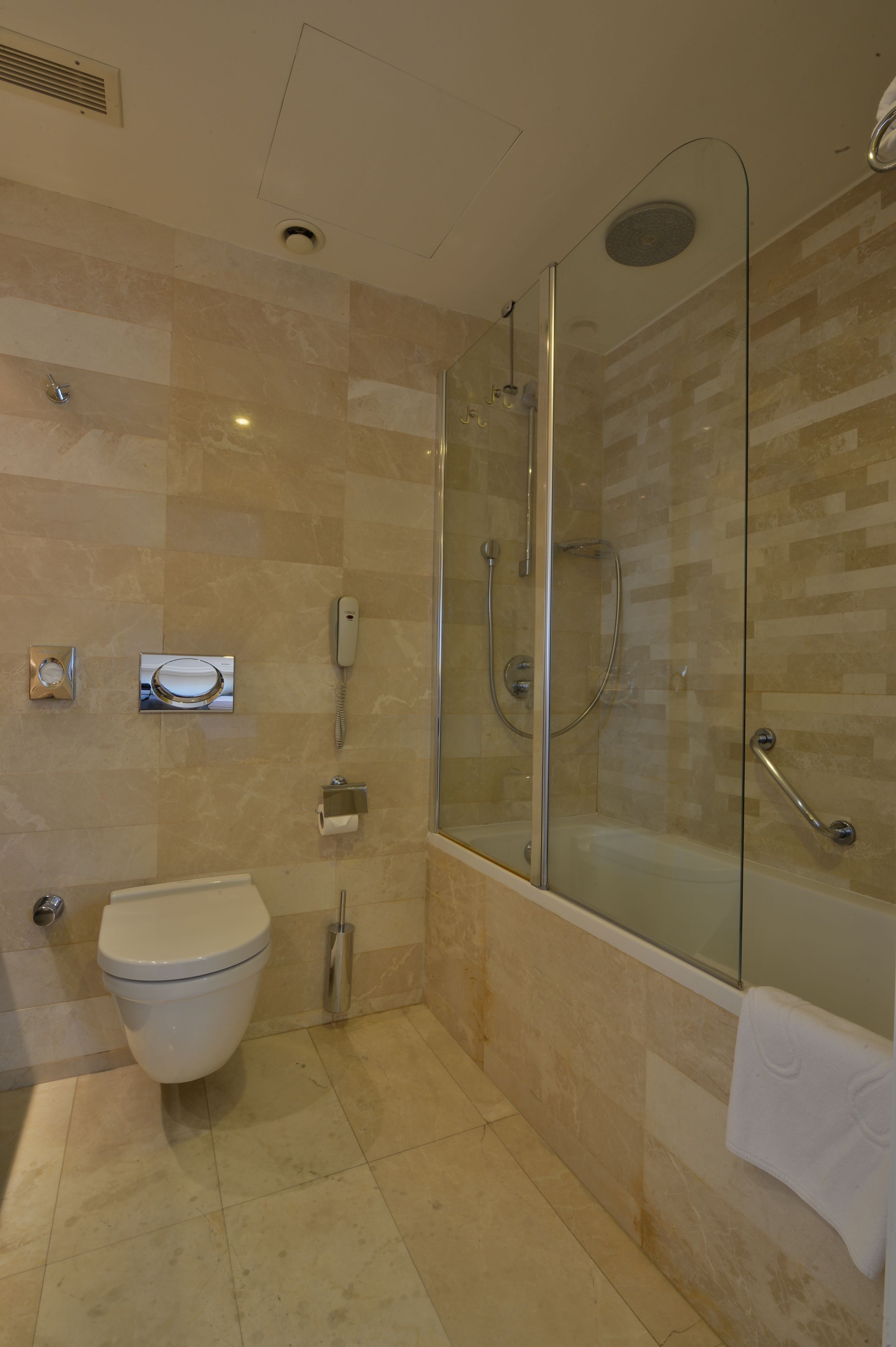 Un bagno moderno con cabina doccia in vetro, un WC e una vasca da bagno.