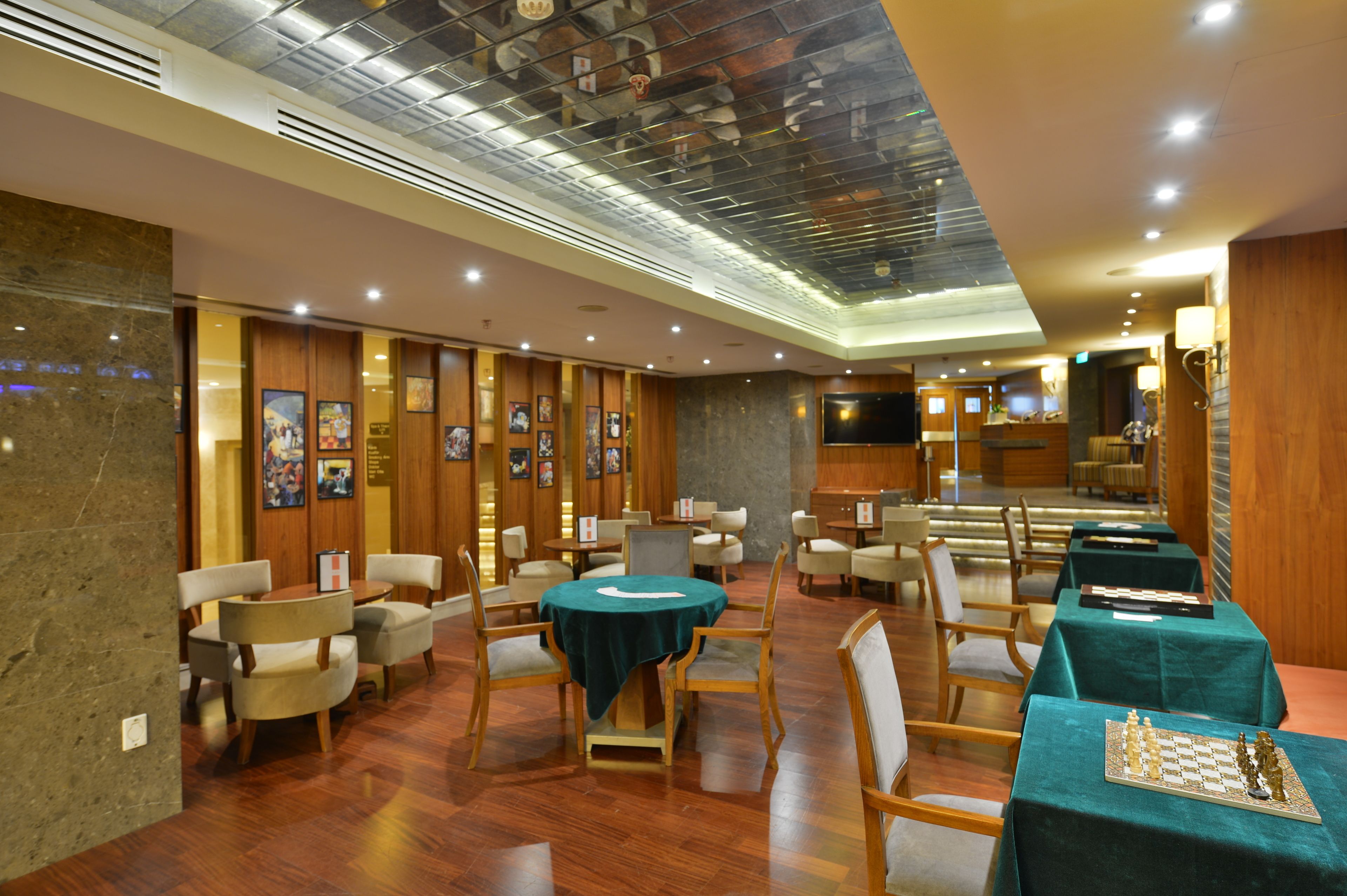 A restaurant with wooden paneling, multiple dining tables with chairs, and a chessboard on one table.