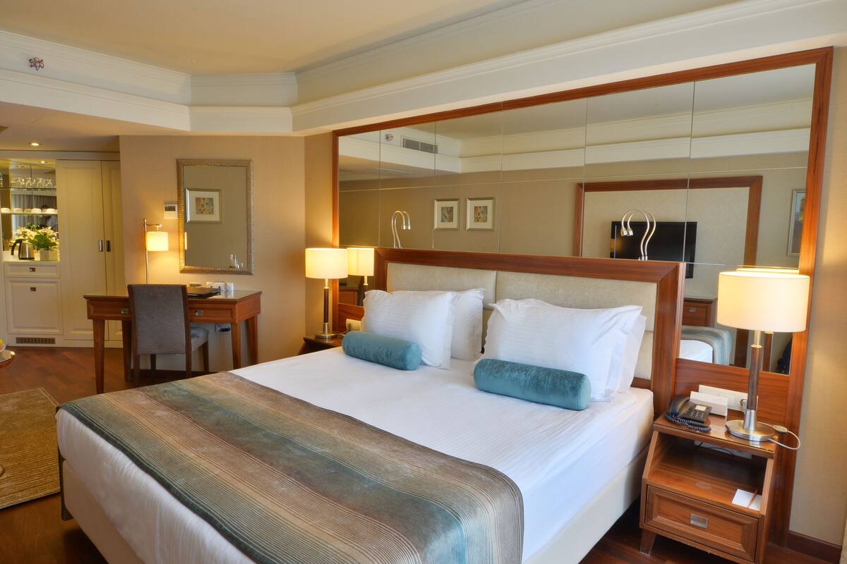 Een hotelkamer met een groot bed, een bureau en een spiegel.