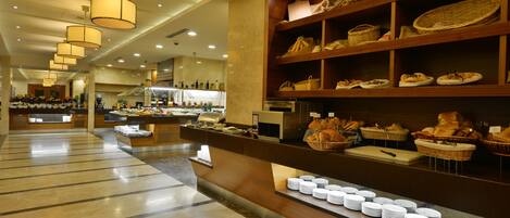 Zona de buffet con diversas opciones de comida y un mostrador con platos y cestas.