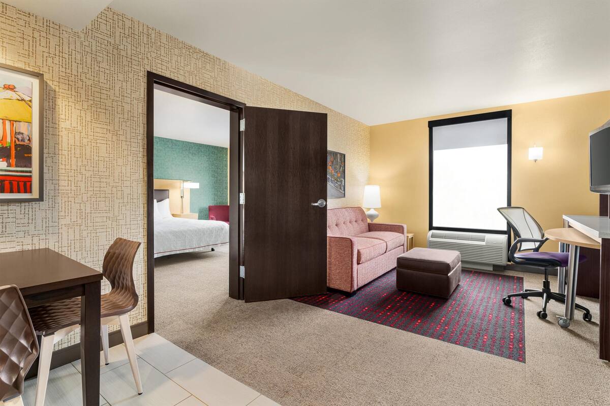 Una habitación de hotel con cama, sofá, escritorio y silla.