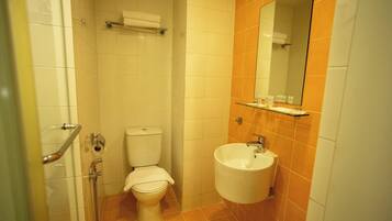 A bathroom with a toilet, sink, and shower.