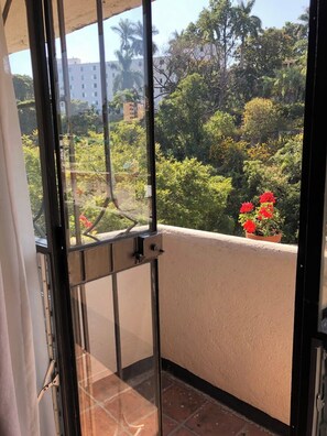 A balcony with a view of a garden and buildings. - Hotel Ilebal Cuernavaca Centro - un lugar con encanto (Cuernavaca)