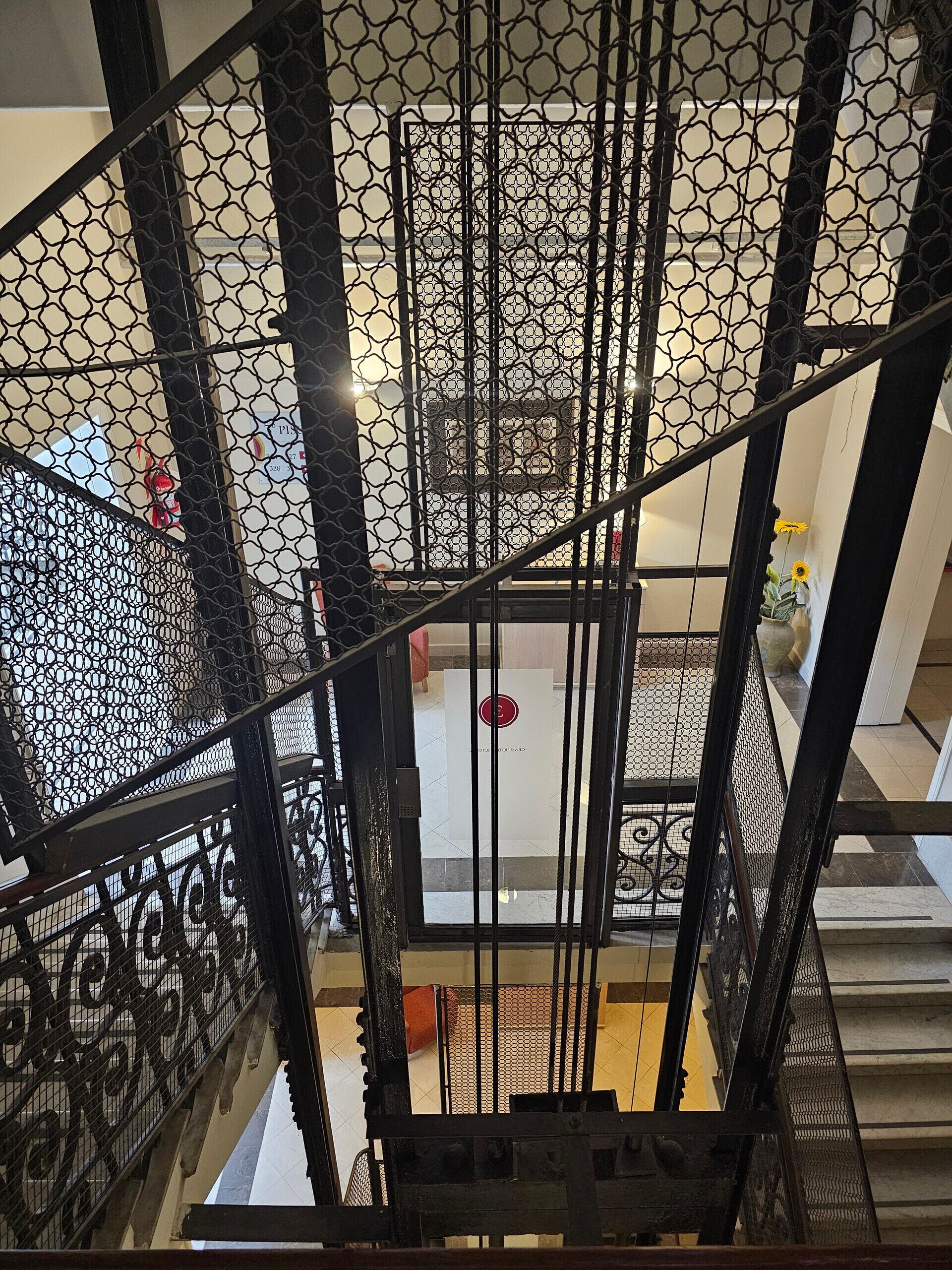 A view from a high vantage point looking down a staircase with a metal railing, leading to a lower level.