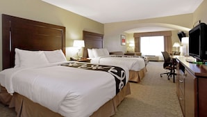 A hotel room with two beds, a desk, a television, and a large window. - La Quinta Inn & Suites by Wyndham Bismarck (Bismarck)