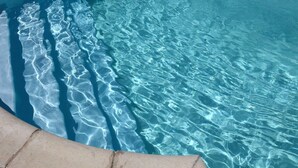 A clear pool with visible ripples and a concrete edge.