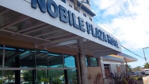 The exterior of a building with a sign reading "NOBLE PLAZA HOTEL".