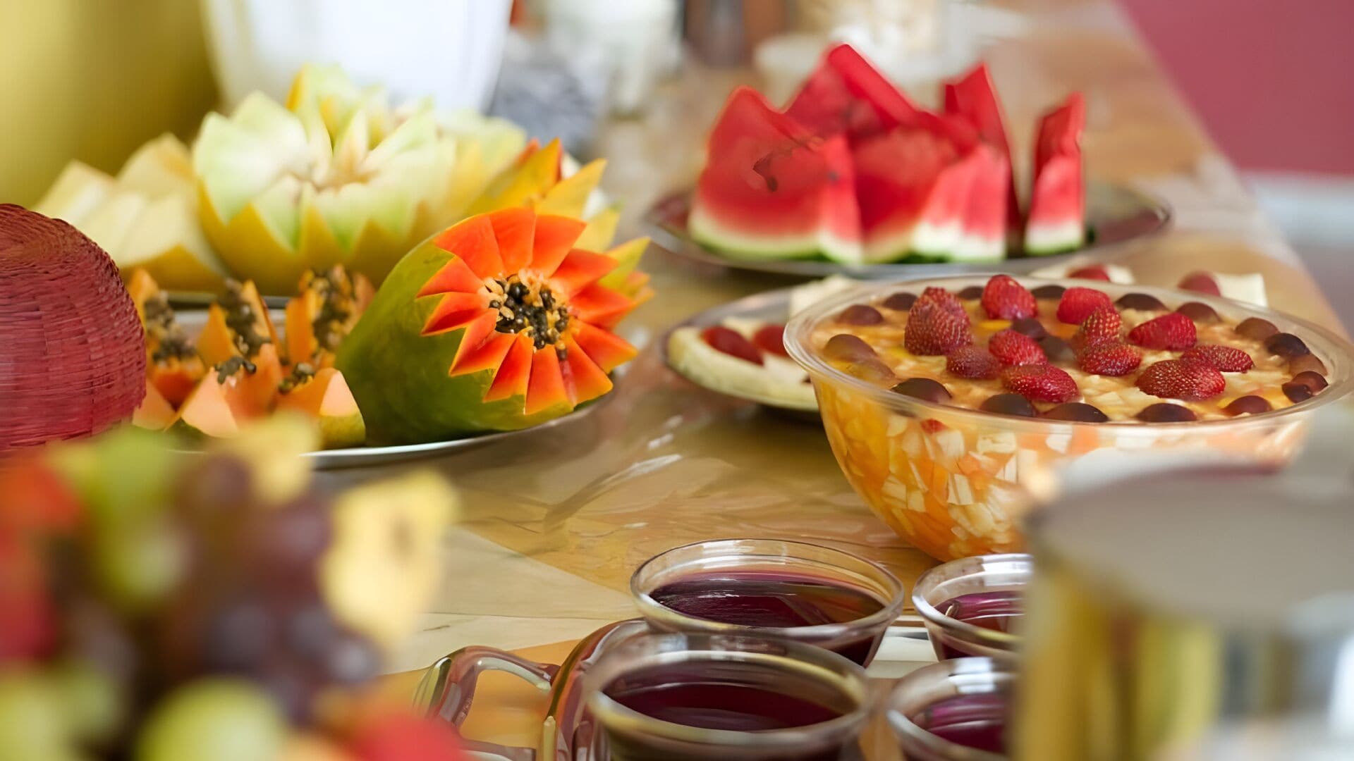 A table with various fruits and a bowl of dessert.