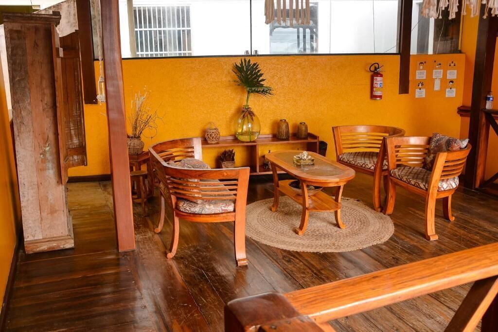 A room with wooden furniture, a round table, and a window with barred glass.