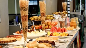 Un buffet proposant une variété de plats, notamment des fruits, des pâtisseries et des boissons.