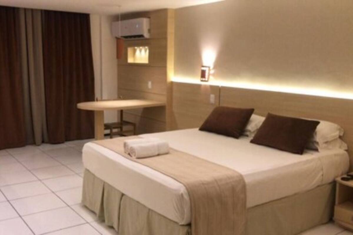 Una habitación de hotel con una cama, un escritorio y una silla.