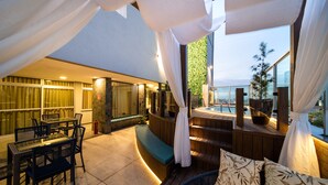 Un espace extérieur aménagé avec des sièges, une piscine, une terrasse en bois et une vue sur la piscine.