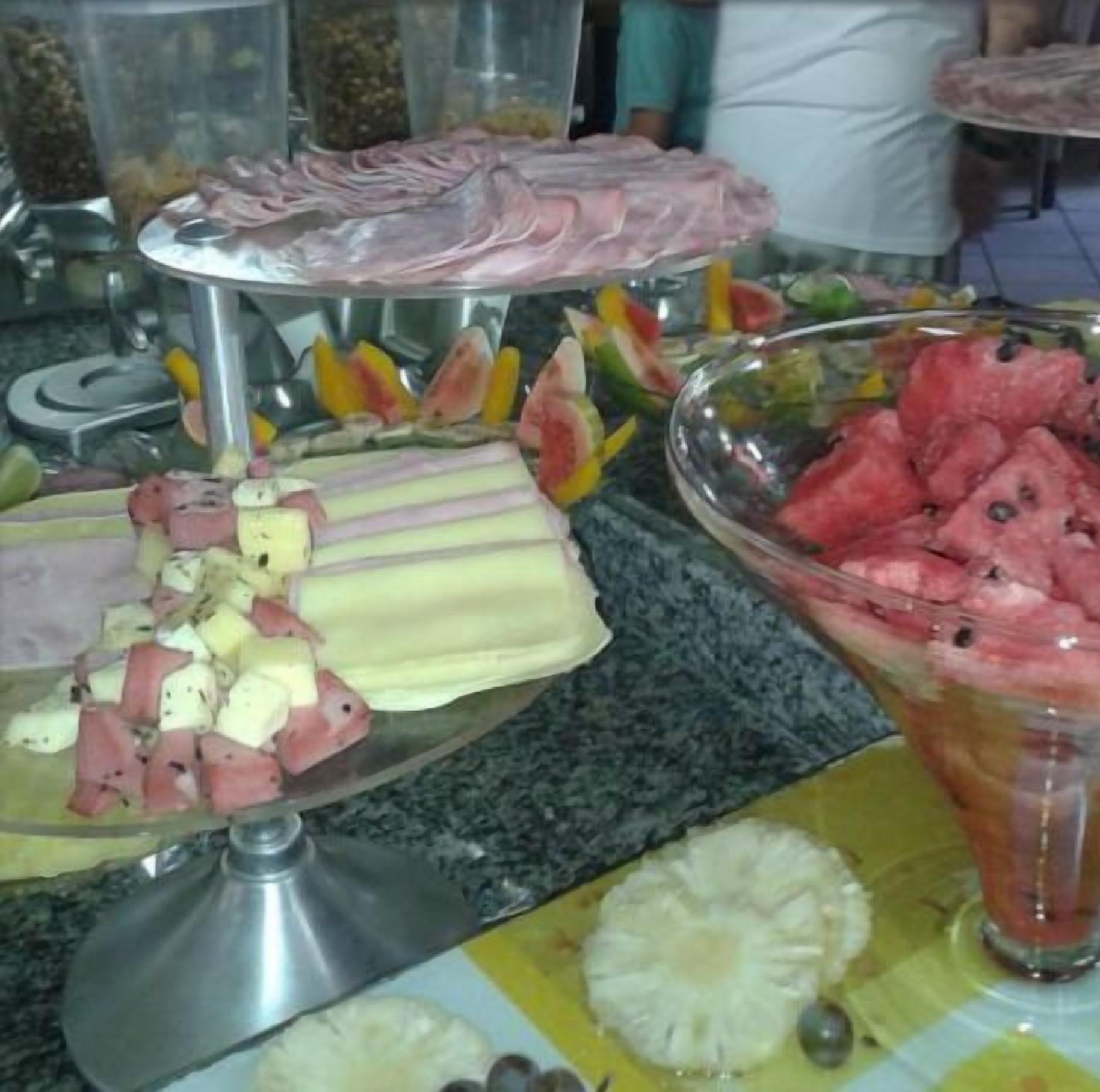 Un buffet proposant une variété de plats, notamment des fruits, de la viande et un plat à base d’ananas.