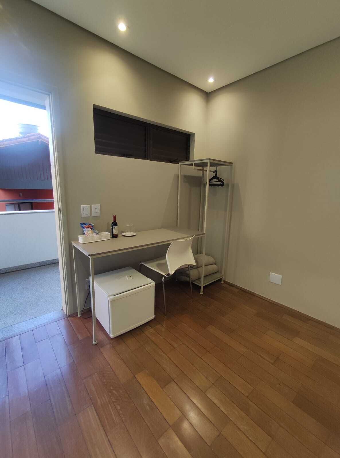 A modern bedroom with a desk, a chair, a wardrobe, and a bed.