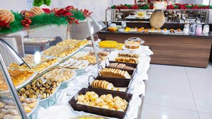 Ein Buffet mit verschiedenen Gebäcken und Desserts, präsentiert in Glasvitrinen und Körben.