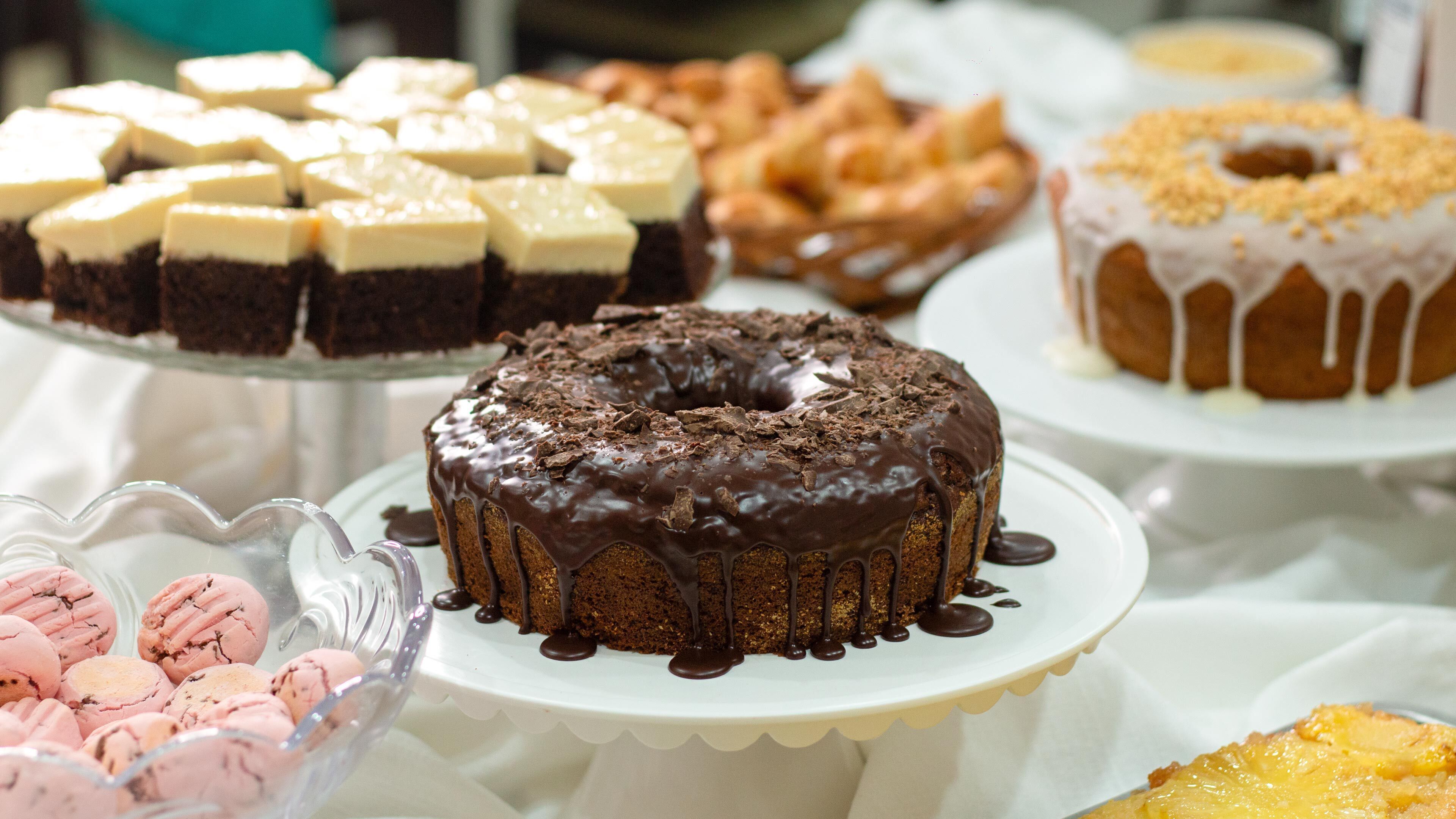 Une variété de desserts étaient disposés sur une table de buffet, notamment un gâteau au chocolat recouvert d’un glaçage blanc et parsemé de copeaux de chocolat.