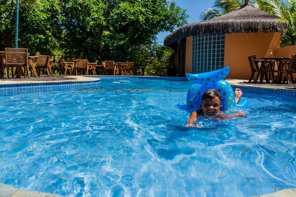 Una piscina al aire libre, sillones reclinables de piscina