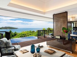 Uma sala de estar moderna com vista para o mar, piscina e área de jantar com um tabuleiro de xadrez.