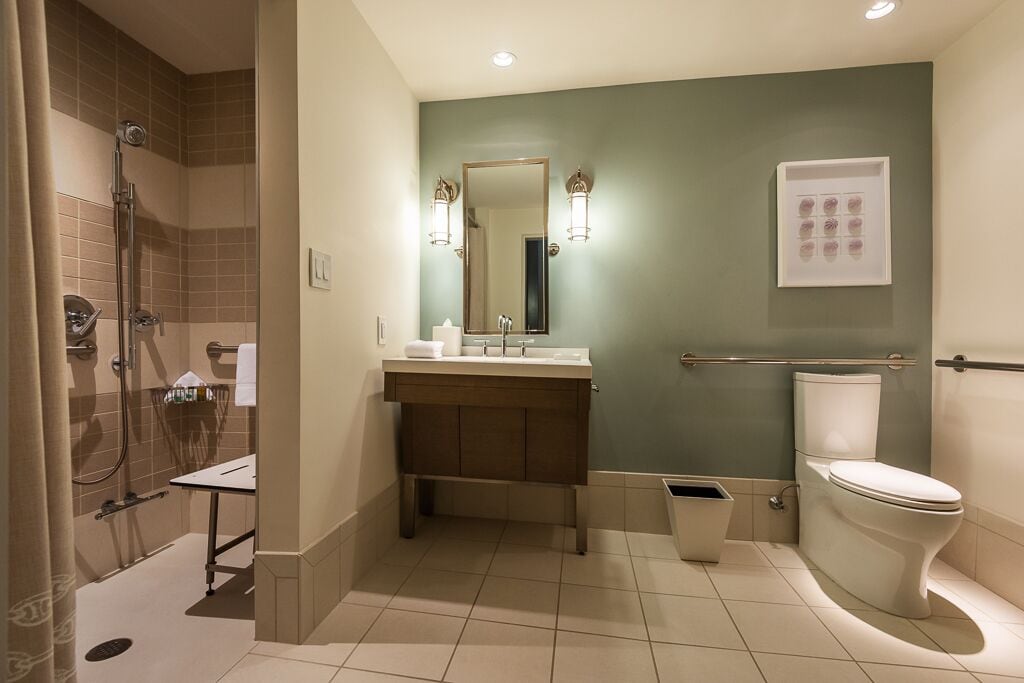 A bathroom with a shower, sink, and toilet.