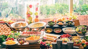 Una mesa de buffet con diversos alimentos y un fondo decorativo.