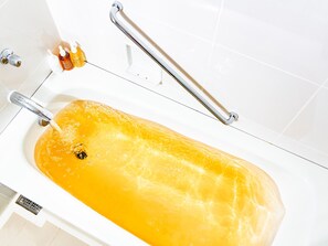 A bathtub filled with water, a faucet, and a handheld showerhead. - Hotel Hanshin Osaka (Osaka)