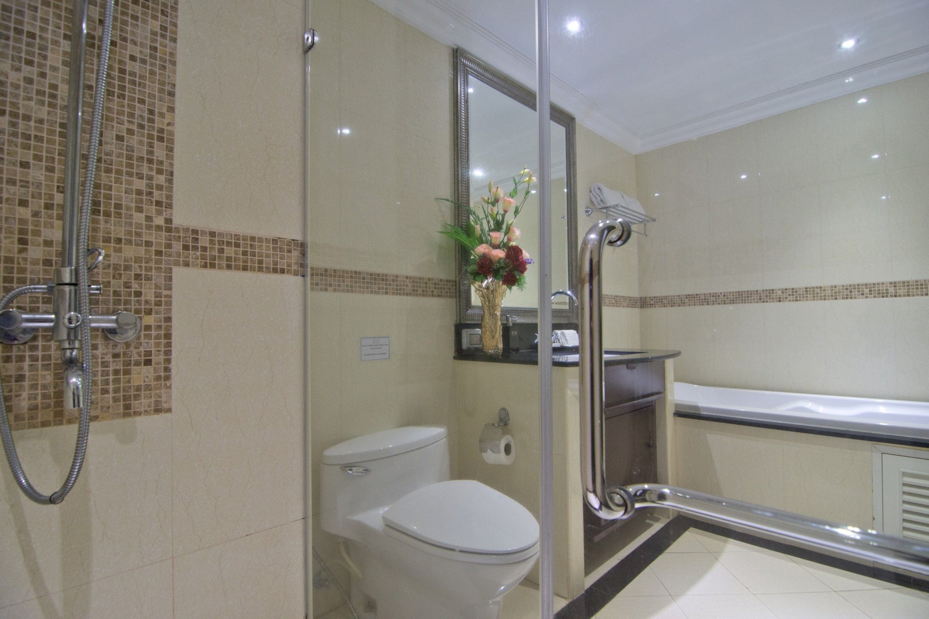 A bathroom with a glass shower enclosure, a toilet, and a vanity with a mirror.