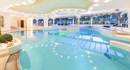 Una piscina techada, una piscina al aire libre de temporada, sombrillas