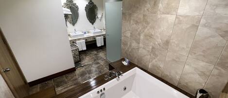 Une salle de bain moderne avec une grande baignoire, deux lavabos et des miroirs décoratifs.