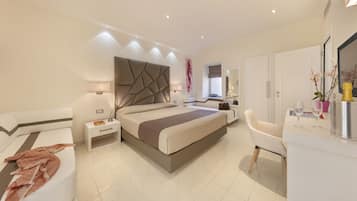 A modern bedroom with a large bed, bedside tables, a vanity with a mirror, and a chair.