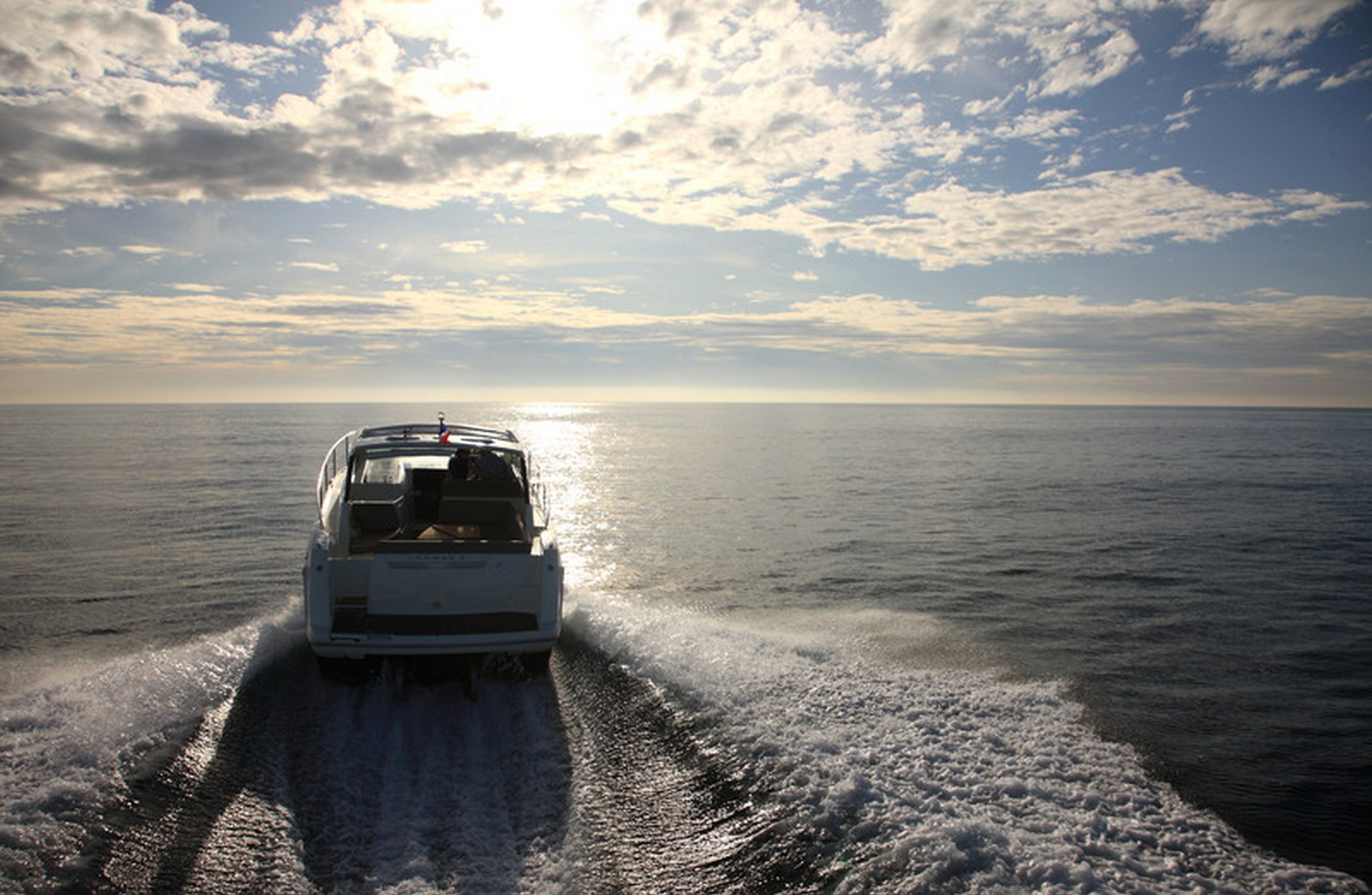 Un barco navegando sobre un mar tranquilo con cielo despejado.