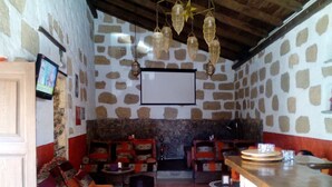 Um interior acolhedor com paredes de pedra, lareira e um espaço de bar.