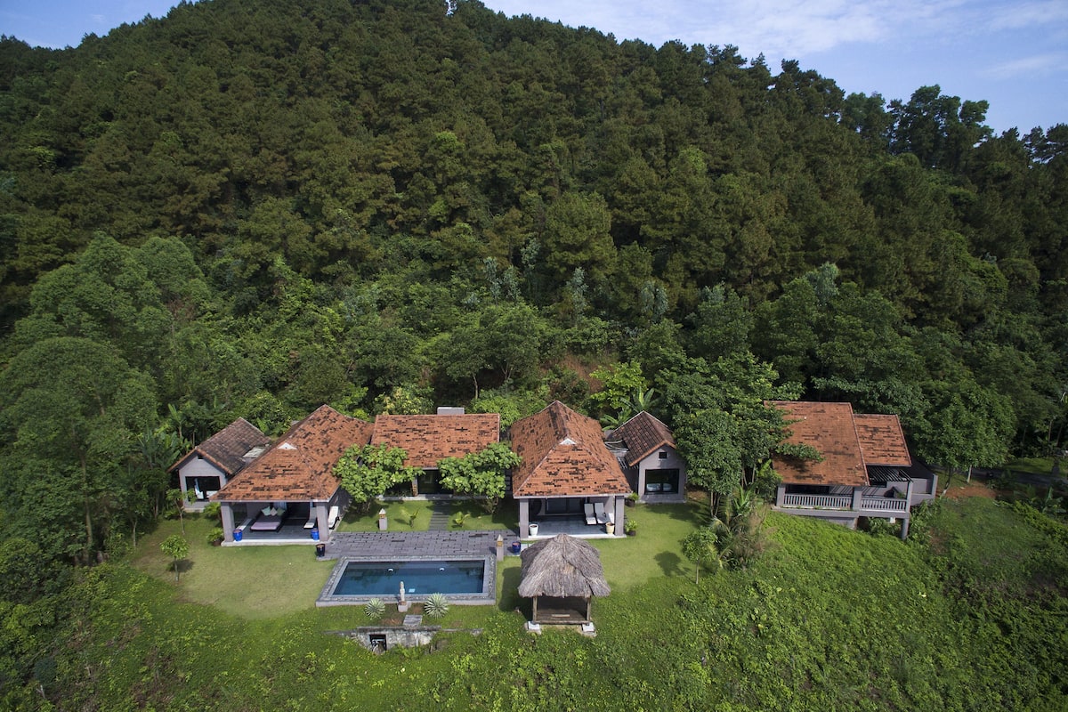 Ein Resort mit mehreren Gebäuden, einem Pool und üppiger Bepflanzung.