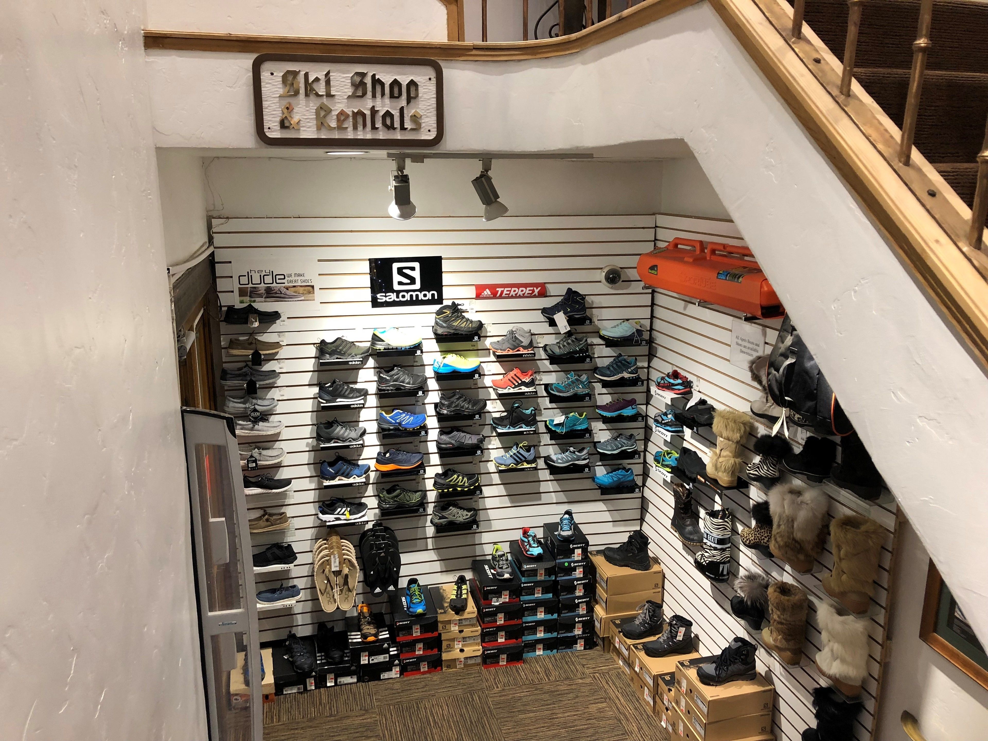 A shoe store with a sign reading "Ski Shop & Rentals" and various brands displayed on shelves.