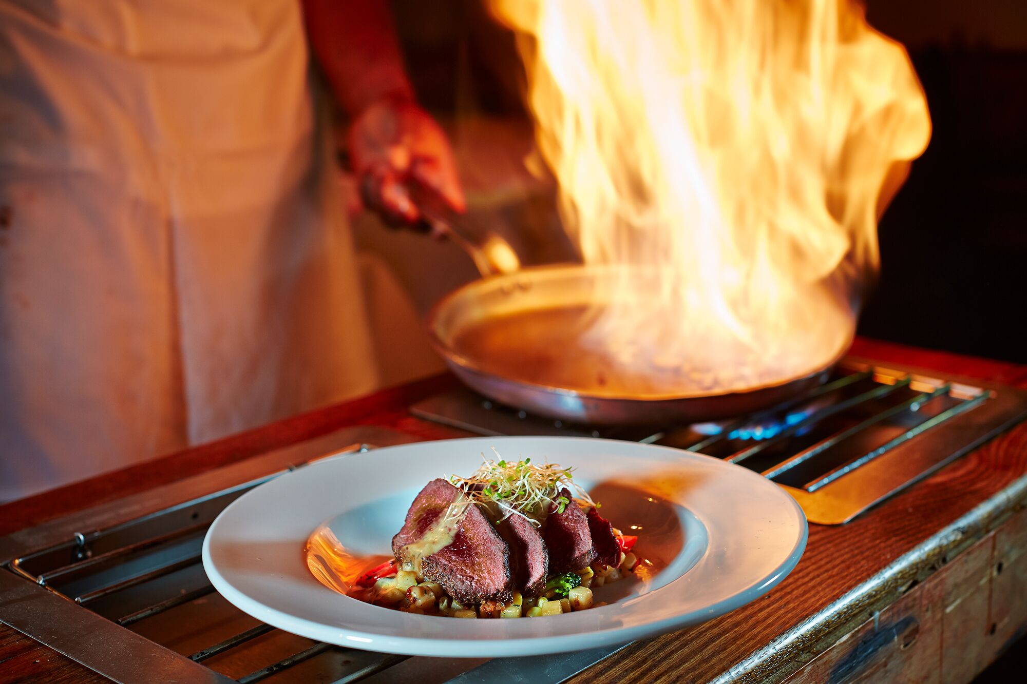 A chef cooking with flames in the background.