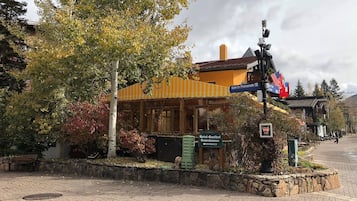 A hotel with a yellow facade, a stone wall, and a sign indicating 'Hotel-Gasthof Granshammer Entrance'.