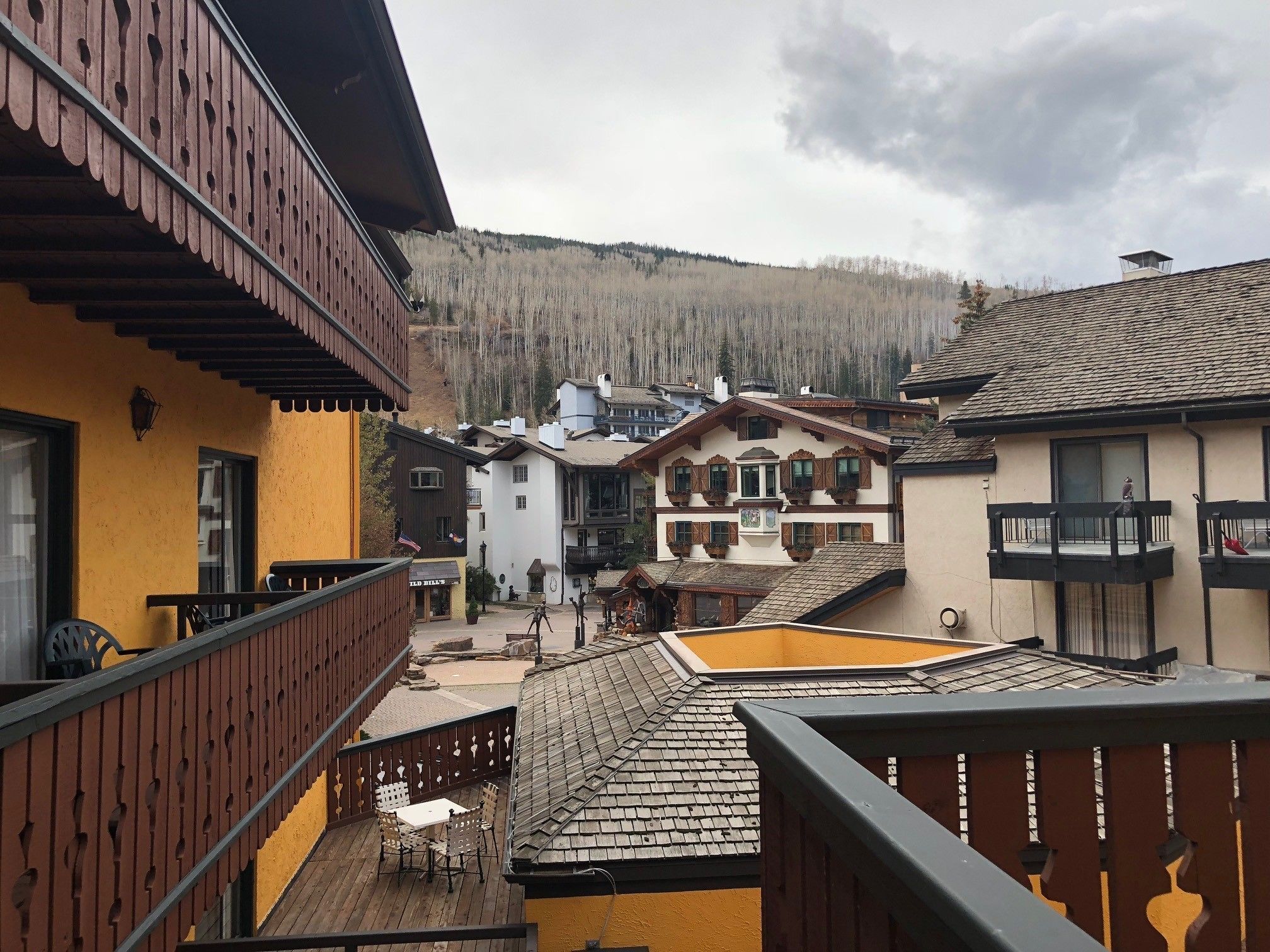 Un bâtiment de style chalet traditionnel, doté d’un balcon en bois et offrant une vue sur un paysage montagneux.