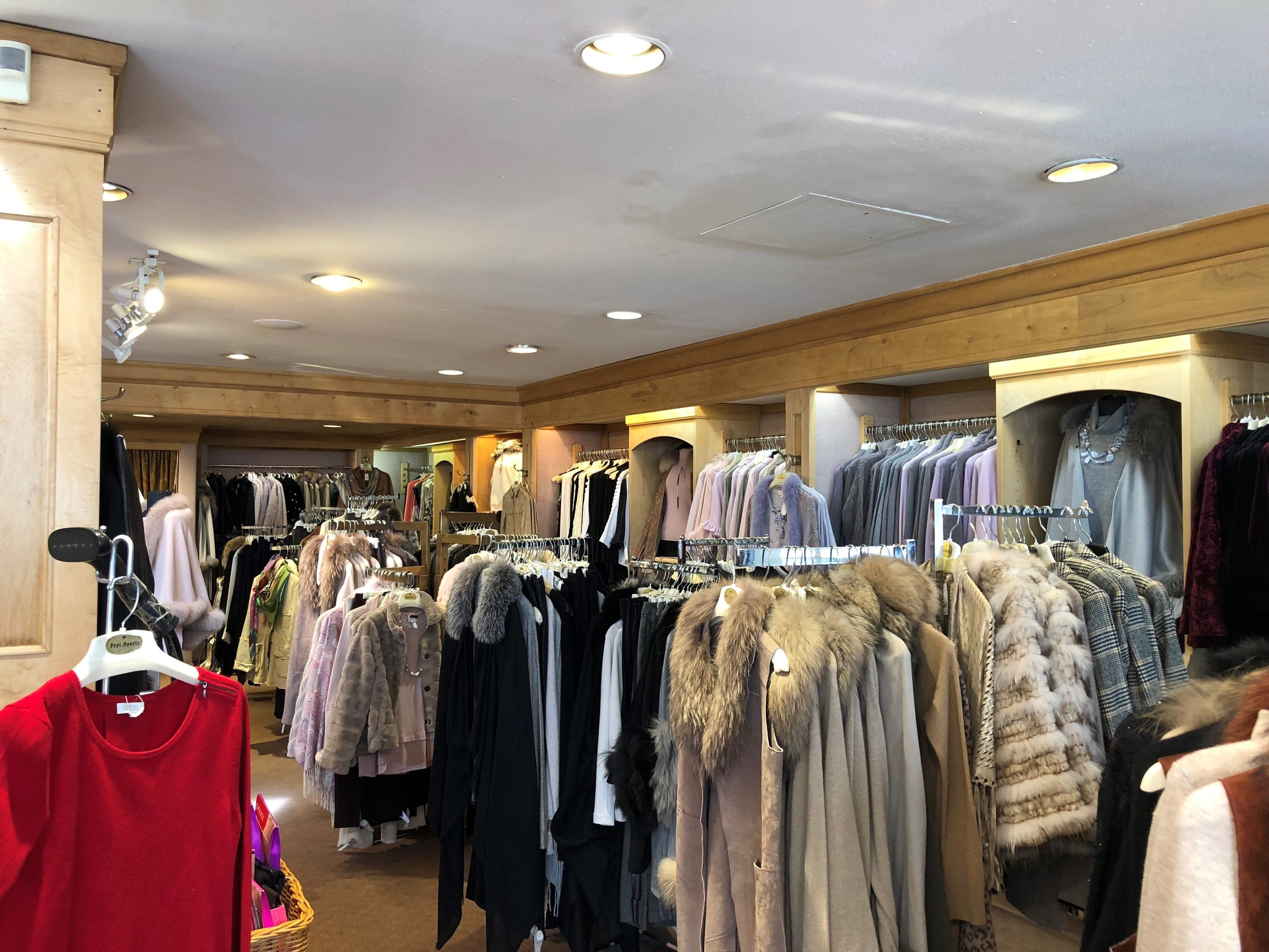 A clothing store with various garments on display, including coats and sweaters.