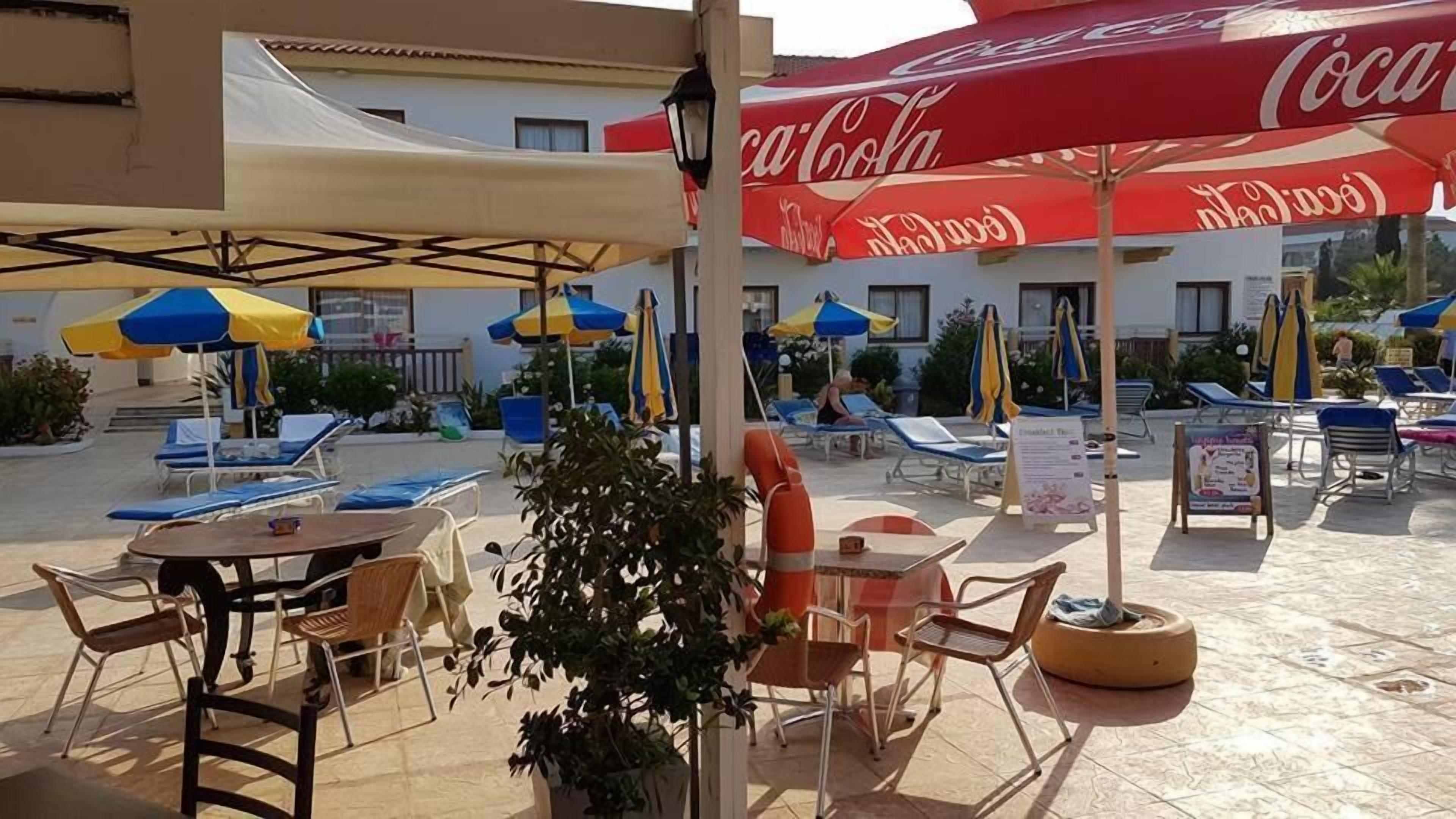 Un espace extérieur aménagé avec des tables, des chaises, des parasols et une bouée de sauvetage.