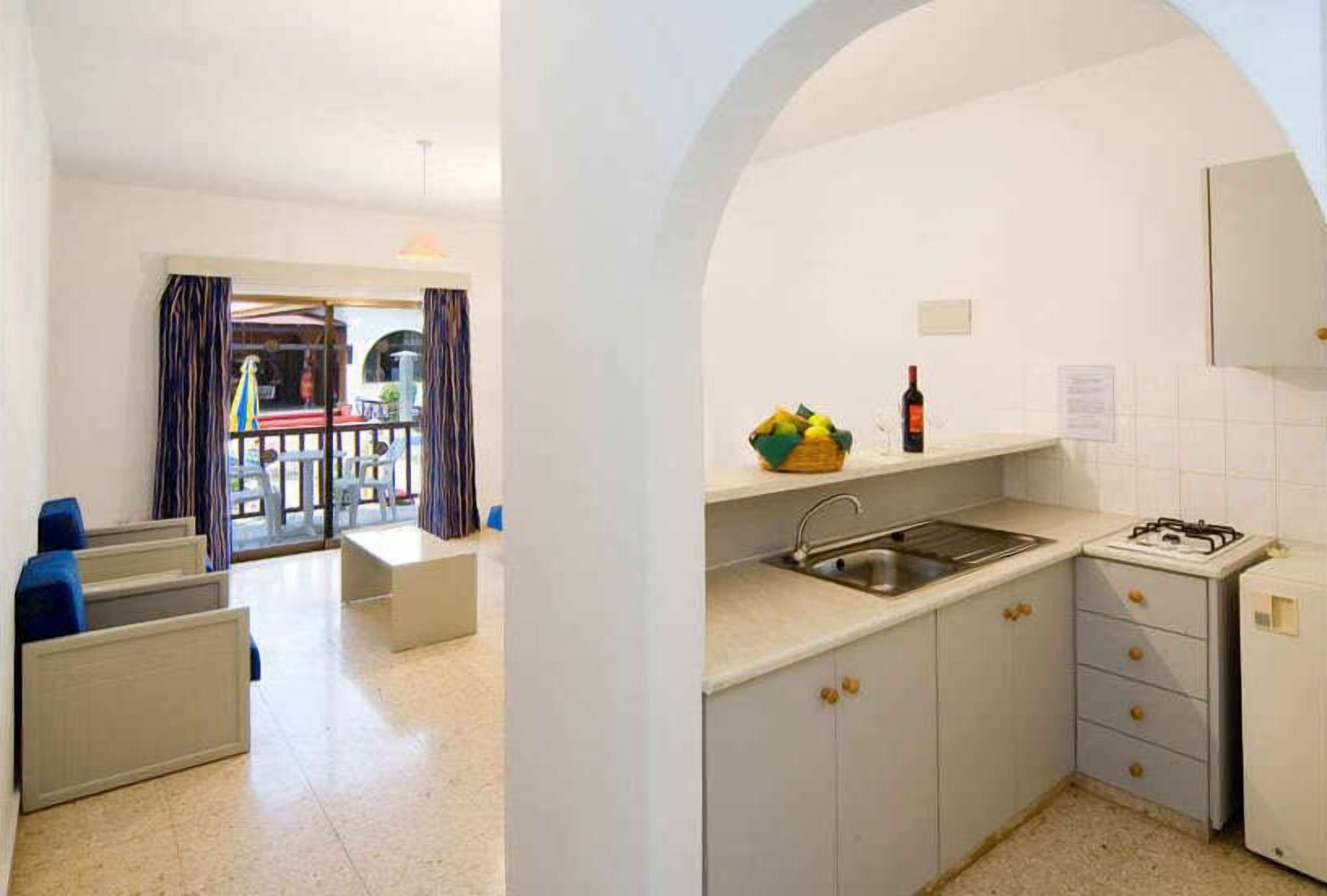 A compact kitchen with a gas stove, sink, and a small countertop.