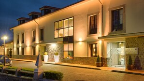 A modern hotel with a well-lit facade, large windows, and a stone accent wall. - La Piconera And Spa (Ribadesella)