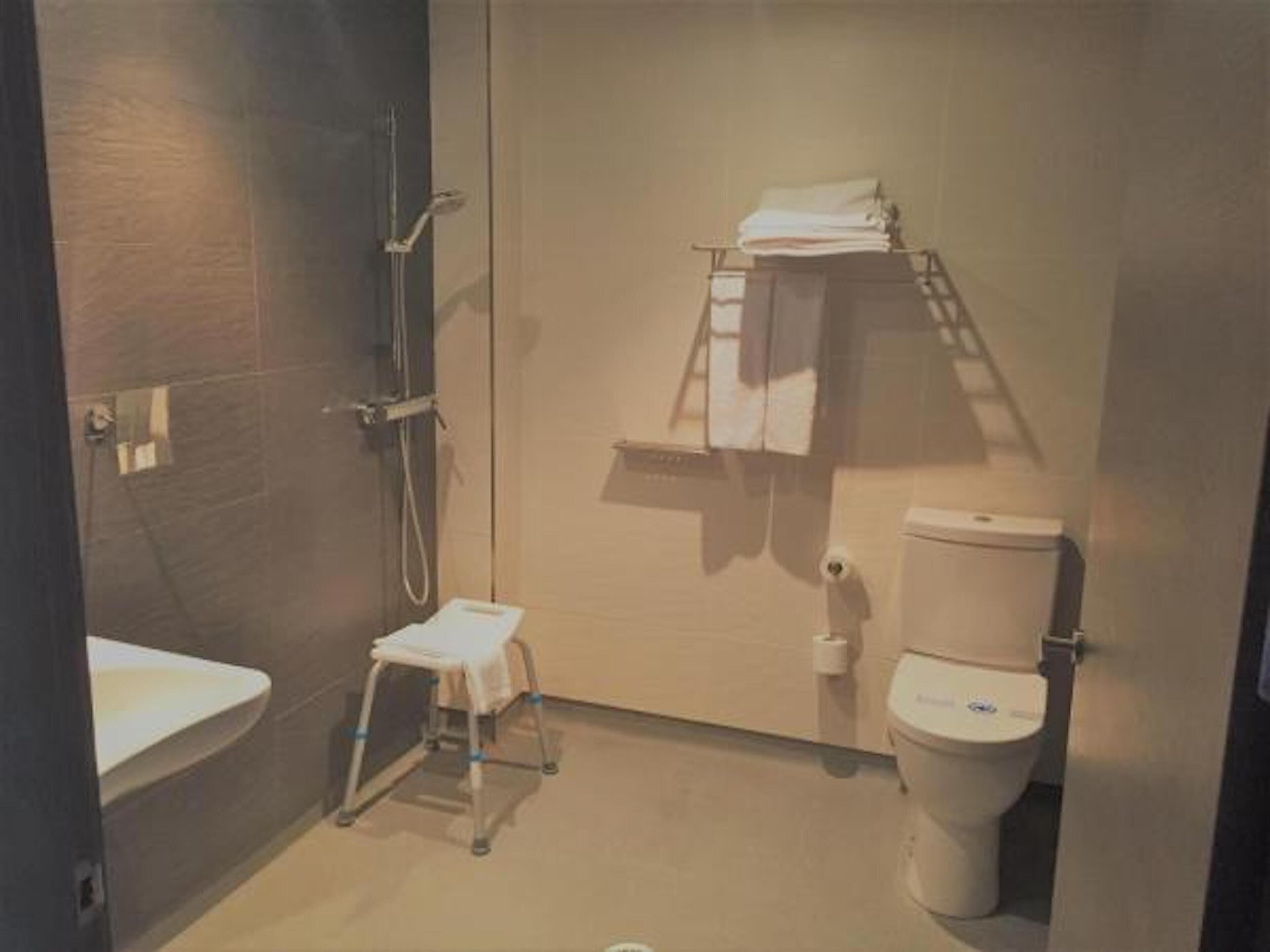 A small, compact bathroom with a toilet, a sink, and a shower.