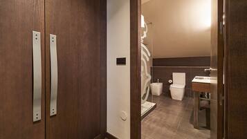 A modern bathroom with a wooden vanity, a toilet, and a sink.